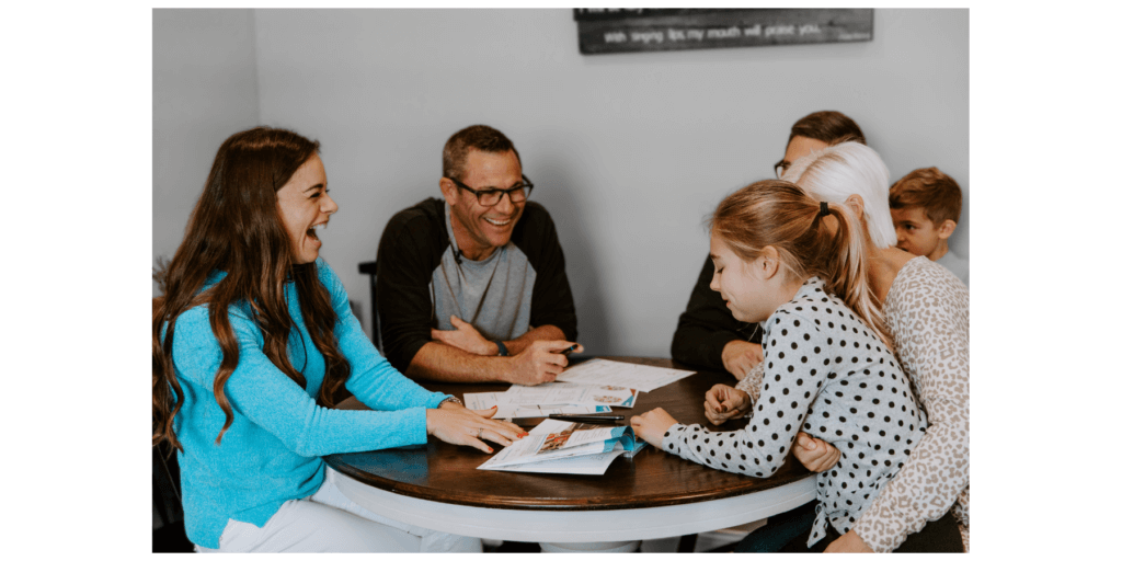 family sitting at table with nutrition coach
