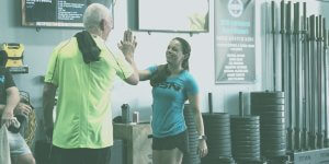 nicole aucoin high fiving a client in the gym