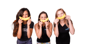 3 nutrition coaches at HSN with a banana over their mouth being funny
