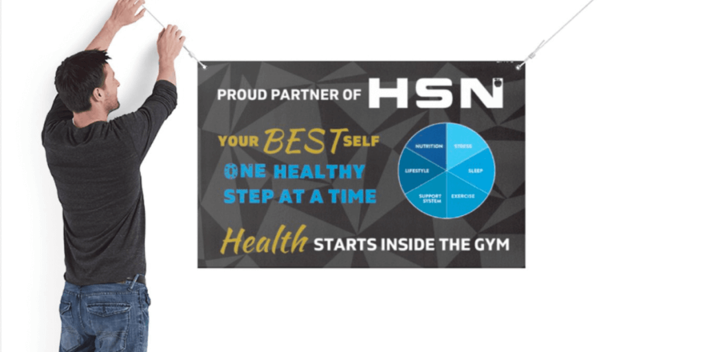 person hanging up banner in a gym to help increase nutrition revenue