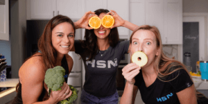 nutrition coaches standing around with fruit over their mouth being funny