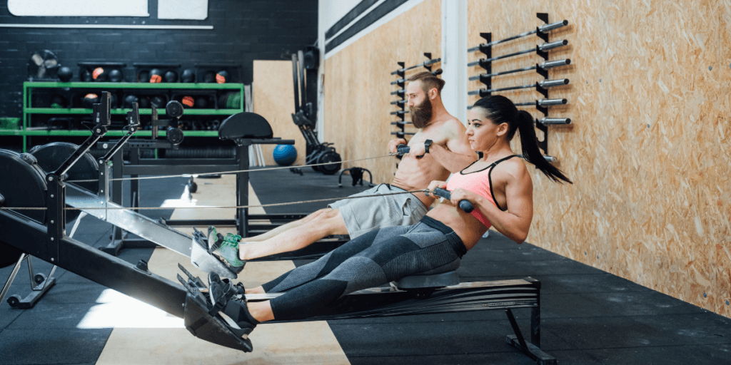 two people rowing in a gym