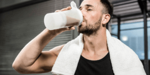 man drinking a recovery protein shake after a crossfit open workout