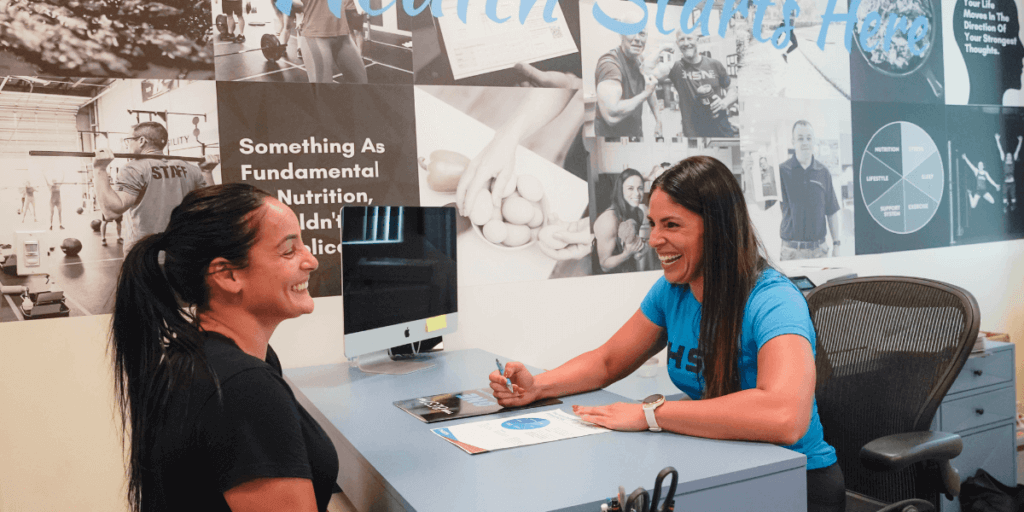 nutrition coach sitting down with client being assessed during a year end review